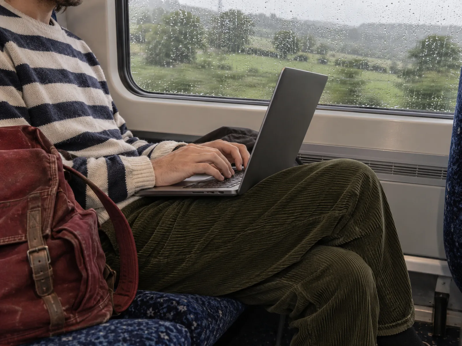 Someone working on a laptop on a train