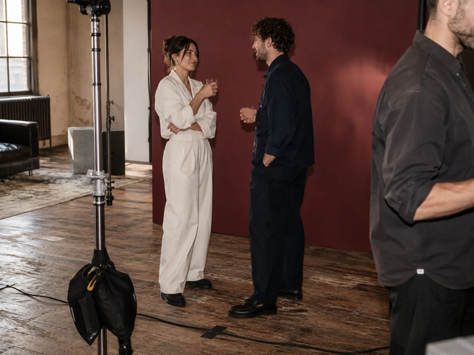People talking on a photo shoot set in front of a red backdrop